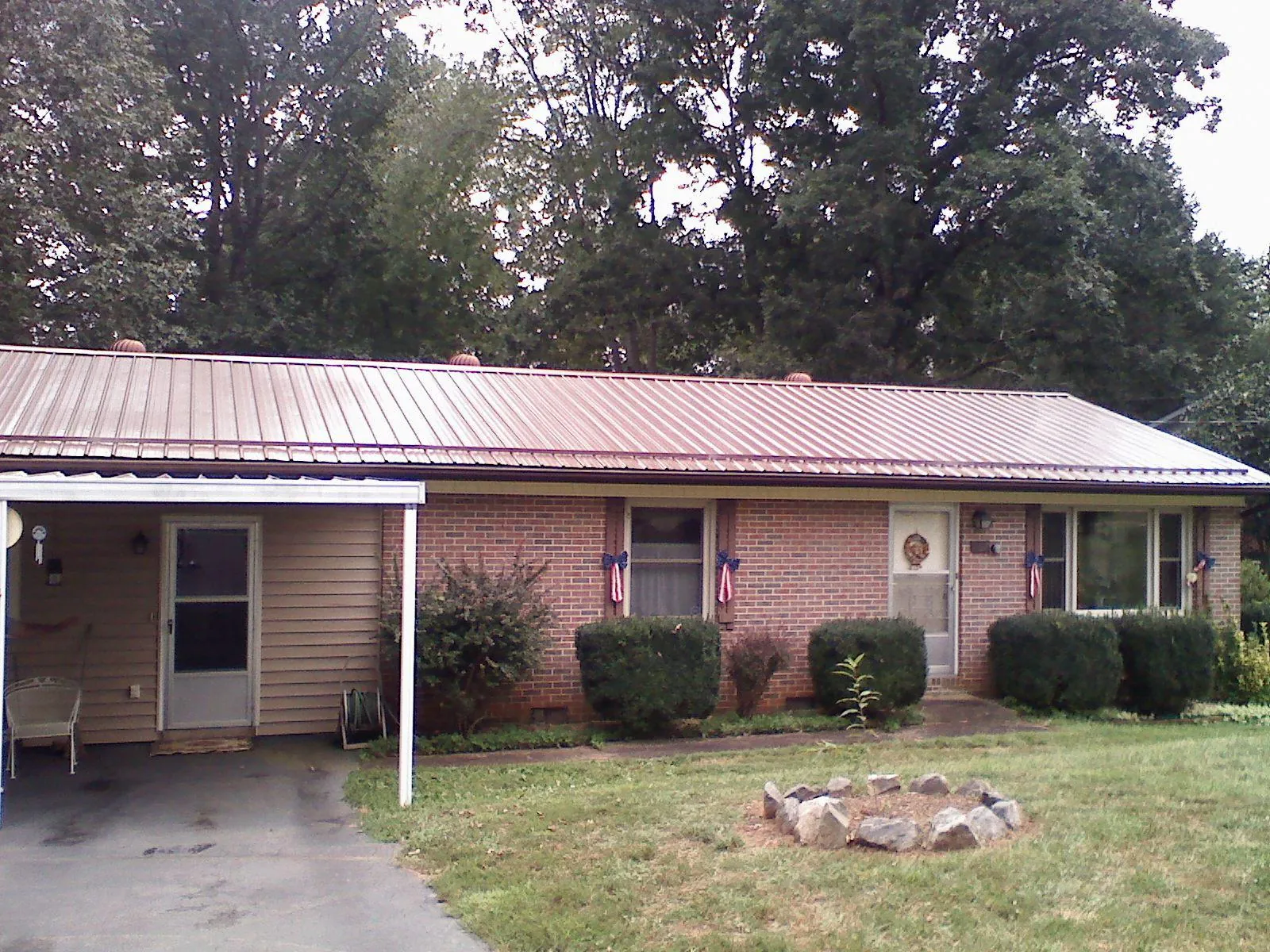 Bronze metal roof and carport on a brick ranch home — Roof Repair work by our crew in Bayard