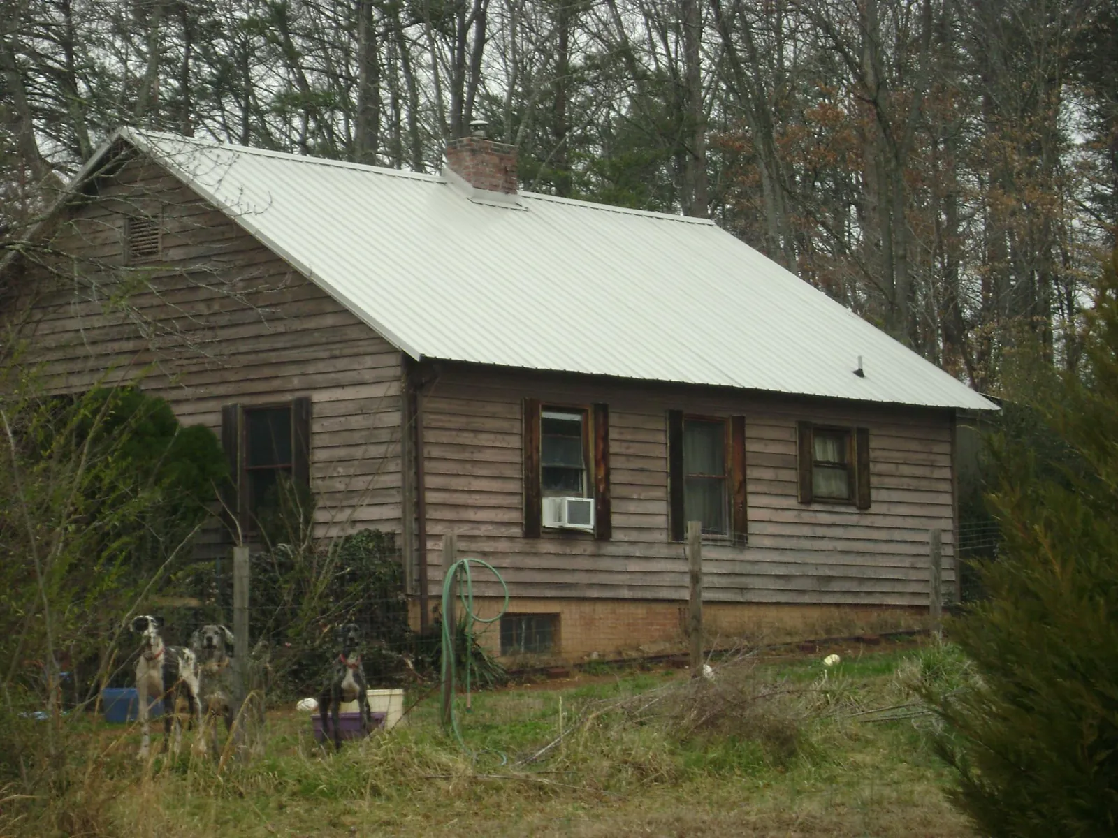 White metal roof on an old wood sided farmhouse, from a Metal Roof Installation job in Bayard